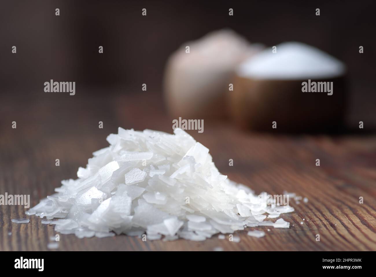 Différents types naturels de sel sur un fond en bois. Cristaux de sel dans un récipient en bois Banque D'Images