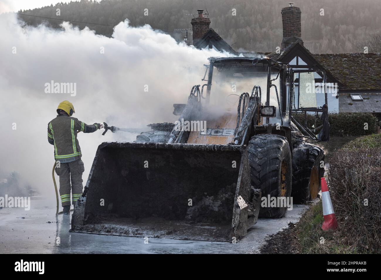 Un pompier du service d'incendie et de sauvetage de Hereford & Worcester utilisant de la mousse pour éteindre un digesteur JCB en feu à Moccas, Herefordshire, Royaume-Uni Banque D'Images