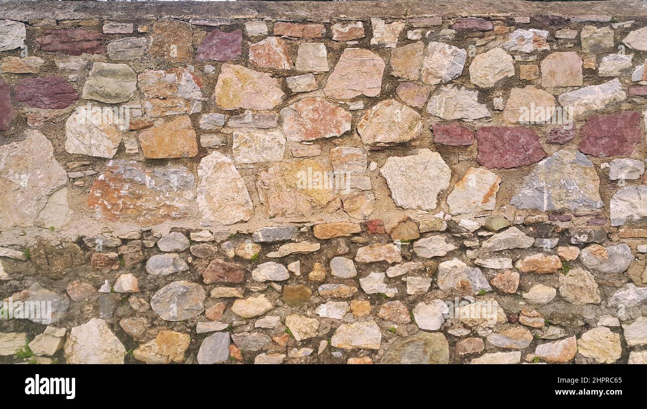 Mur en pierre construit à différents moments. Deux textures de paroi de pierre différentes. Banque D'Images