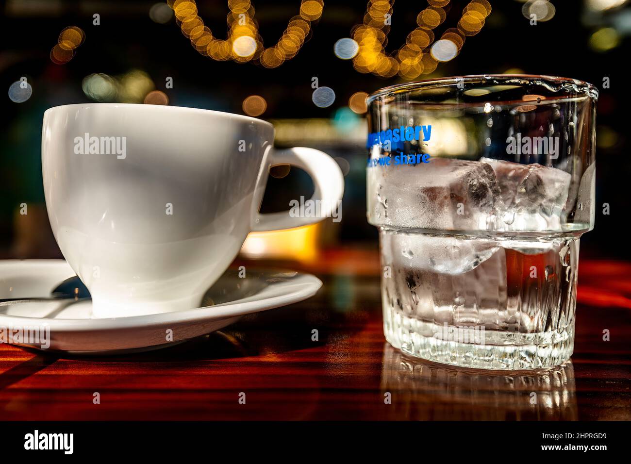 Une tasse blanche et un verre transparent avec de la glace sur une table en bois. Banque D'Images