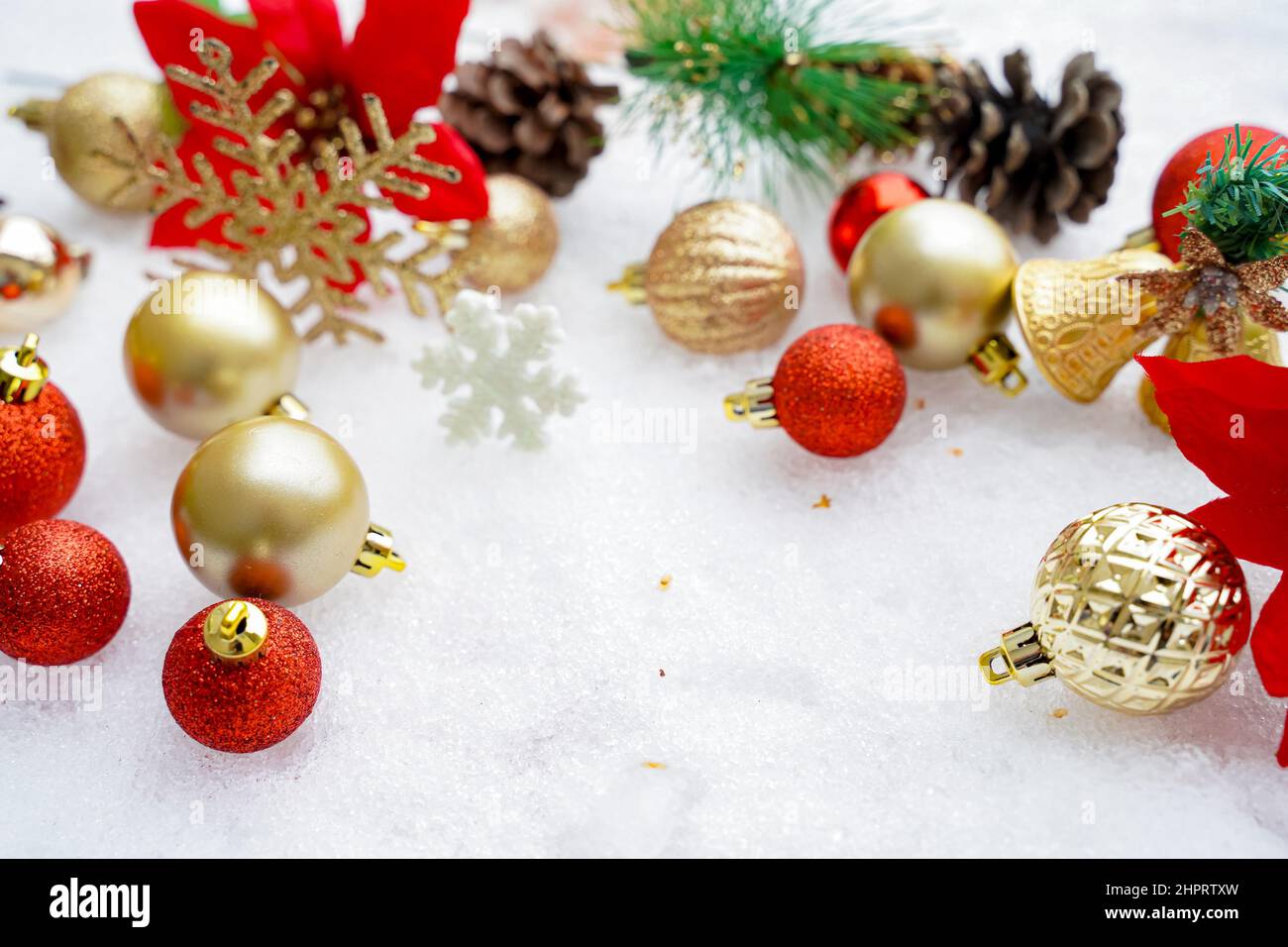 Noël de l'hiver - boules de Noël avec ruban sur la neige, concept de vacances d'hiver. Boules rouges de Noël, boules dorées, décoration de pin et de flocons de neige Banque D'Images