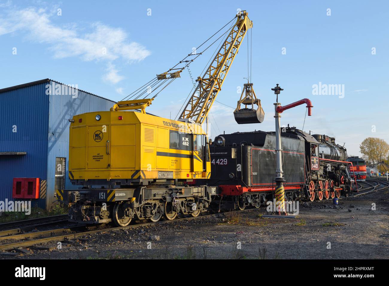 SORTAVALA, RUSSIE - 07 OCTOBRE 2021 : la grue de chemin de fer KZH-462 'Pervomaets' charge la locomotive à vapeur de charbon L-4429 le matin ensoleillé Banque D'Images