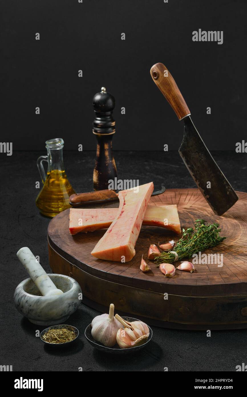 Grande moelle osseuse de bœuf hachée sur la moitié avec des épices sur une souche de bois Banque D'Images