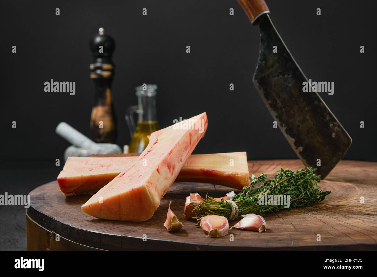 Grande moelle osseuse de boeuf hachée sur la moitié avec des épices et des herbes sur la souche en bois Banque D'Images