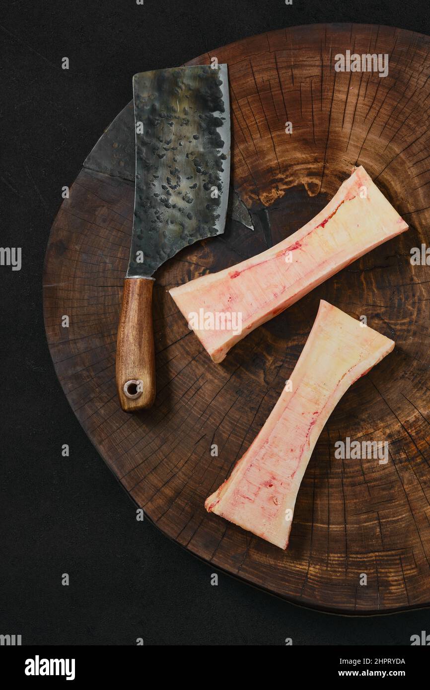 Vue en hauteur de la grande moelle osseuse de bœuf hachée sur la moitié sur une souche de bois Banque D'Images