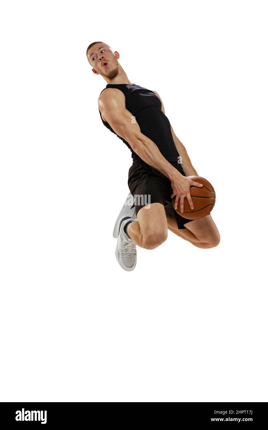 Portrait dynamique d'un joueur de basket-ball sautant avec balle isolée sur fond blanc de studio. Concepts de sport, de mouvement, d'activité. Dunk, Jam, Stuff Banque D'Images