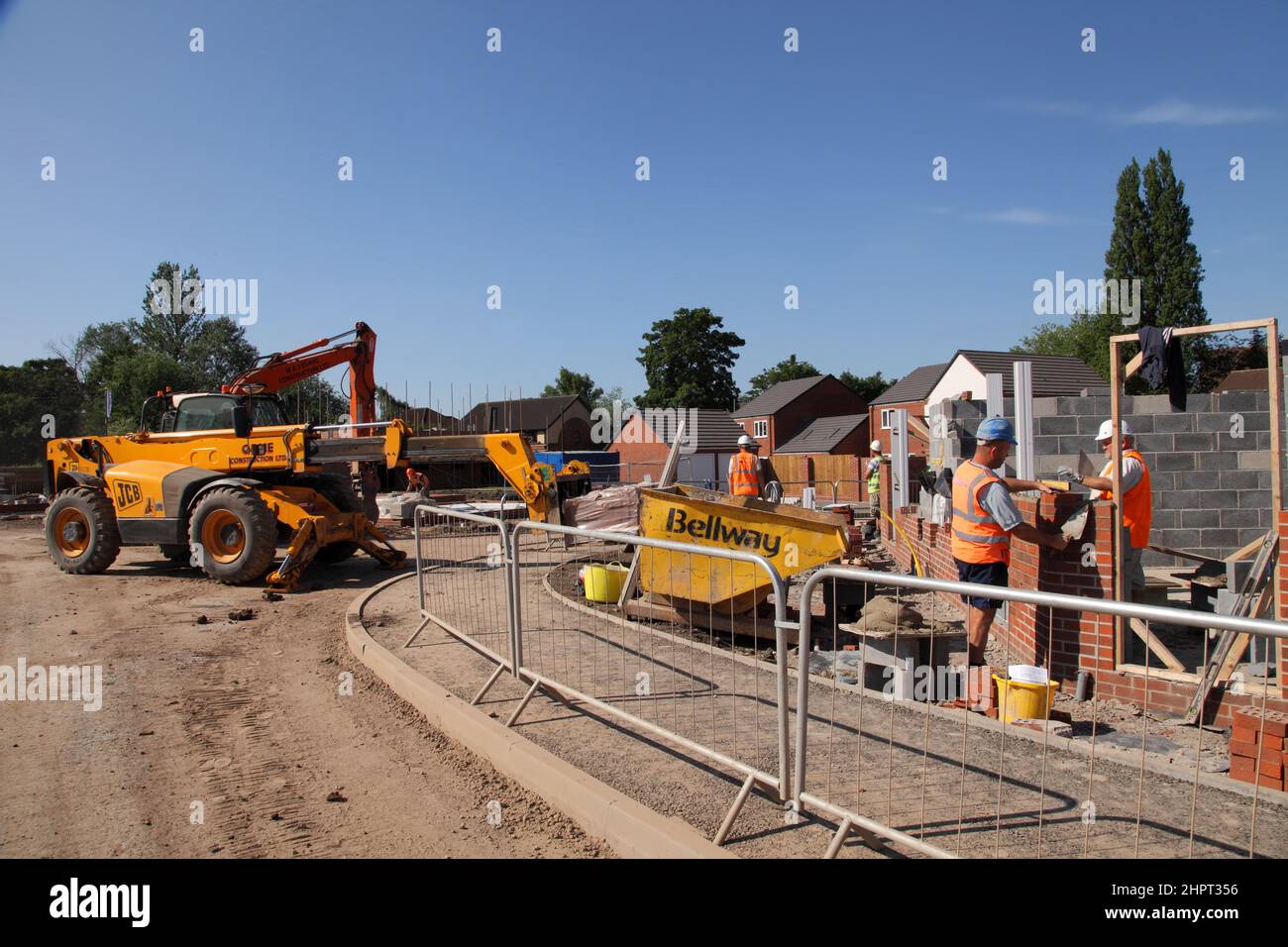Des constructeurs et des couches de briques travaillent sur un site de construction Bellway Homes dans les West Midlands, en Angleterre, au Royaume-Uni Banque D'Images