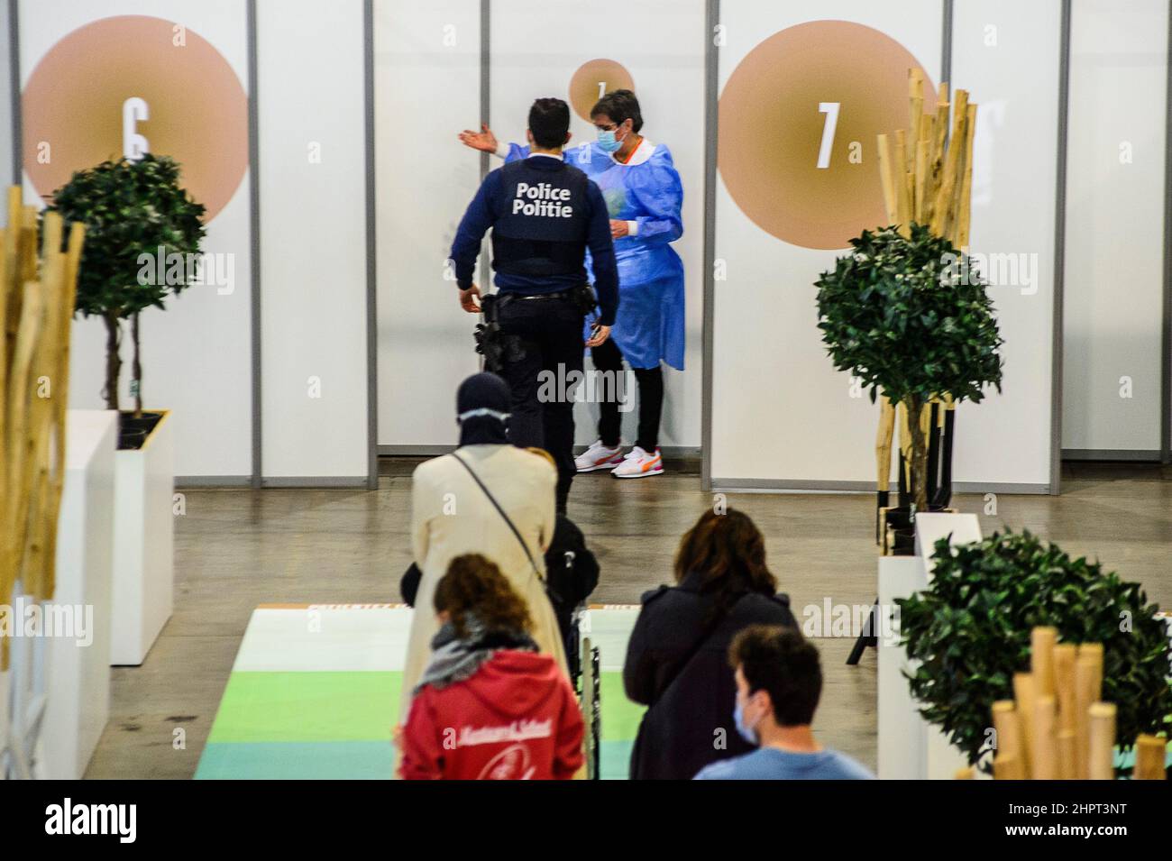 File d'attente au Centre de vaccination de Bruxelles Expo. L'infirmière sort la boîte pour inviter le patient à inoculer les gens font la file dans le centre Banque D'Images File d'attente au Centre de vaccination de Bruxelles Expo. L'infirmière sort la boîte pour inviter le patient à inoculer les gens font la file dans le centre Banque D'Images