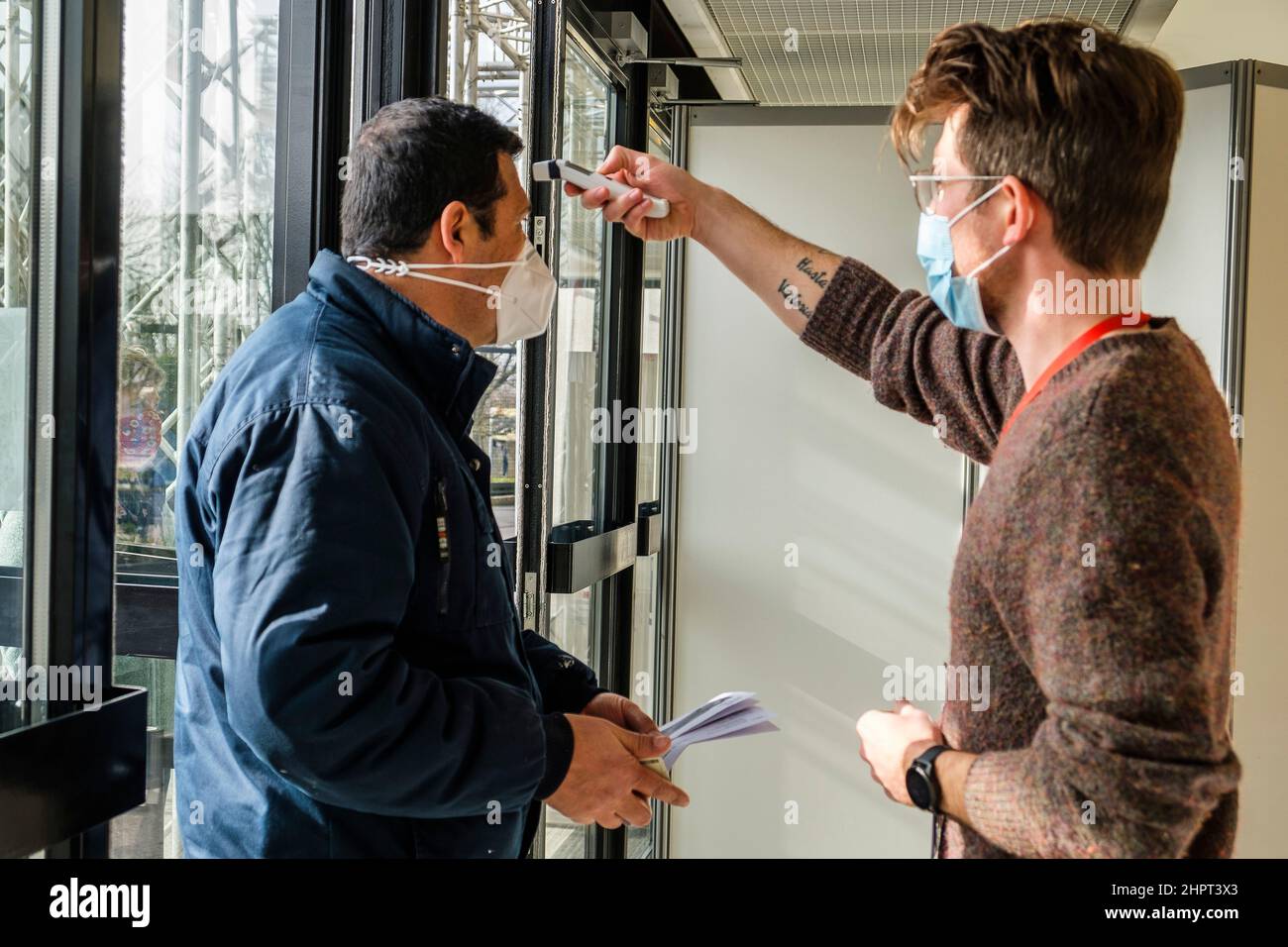 File d'attente devant le Centre de vaccination de Bruxelles Expo. Mesure de température à l'entrée principale les gens font la file devant et dans le centre Banque D'Images File d'attente devant le Centre de vaccination de Bruxelles Expo. Mesure de température à l'entrée principale les gens font la file devant et dans le centre Banque D'Images