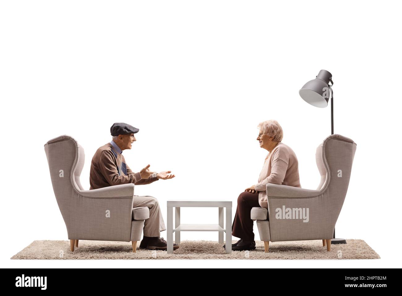 Photo de profil d'un homme et d'une femme âgés assis dans des fauteuils et parlant isolés sur fond blanc Banque D'Images