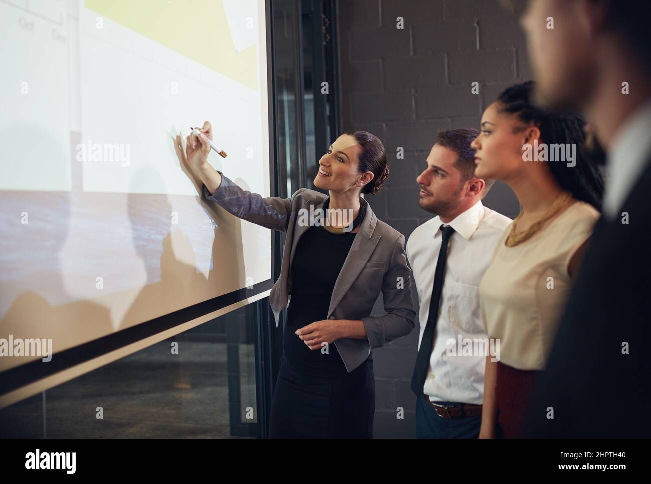 Faire participer son équipe au processus commercial. Photo d'un cadre donnant une présentation sur un écran de projection à un groupe de collègues dans un Banque D'Images