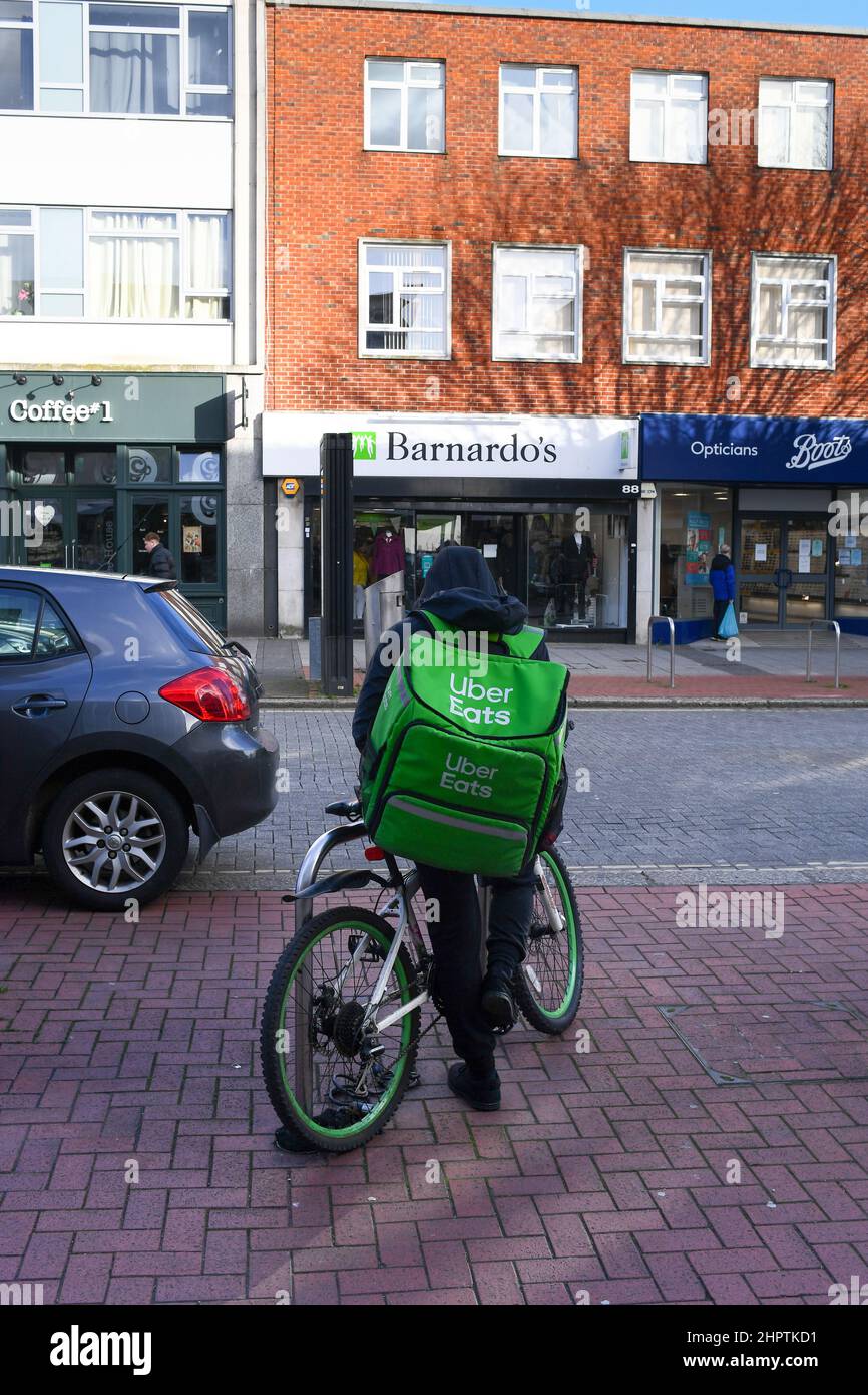Un über mange le cycliste de livraison avec le sac à dos attend sa prochaine livraison de nourriture dans la ville de Southampton. Banque D'Images