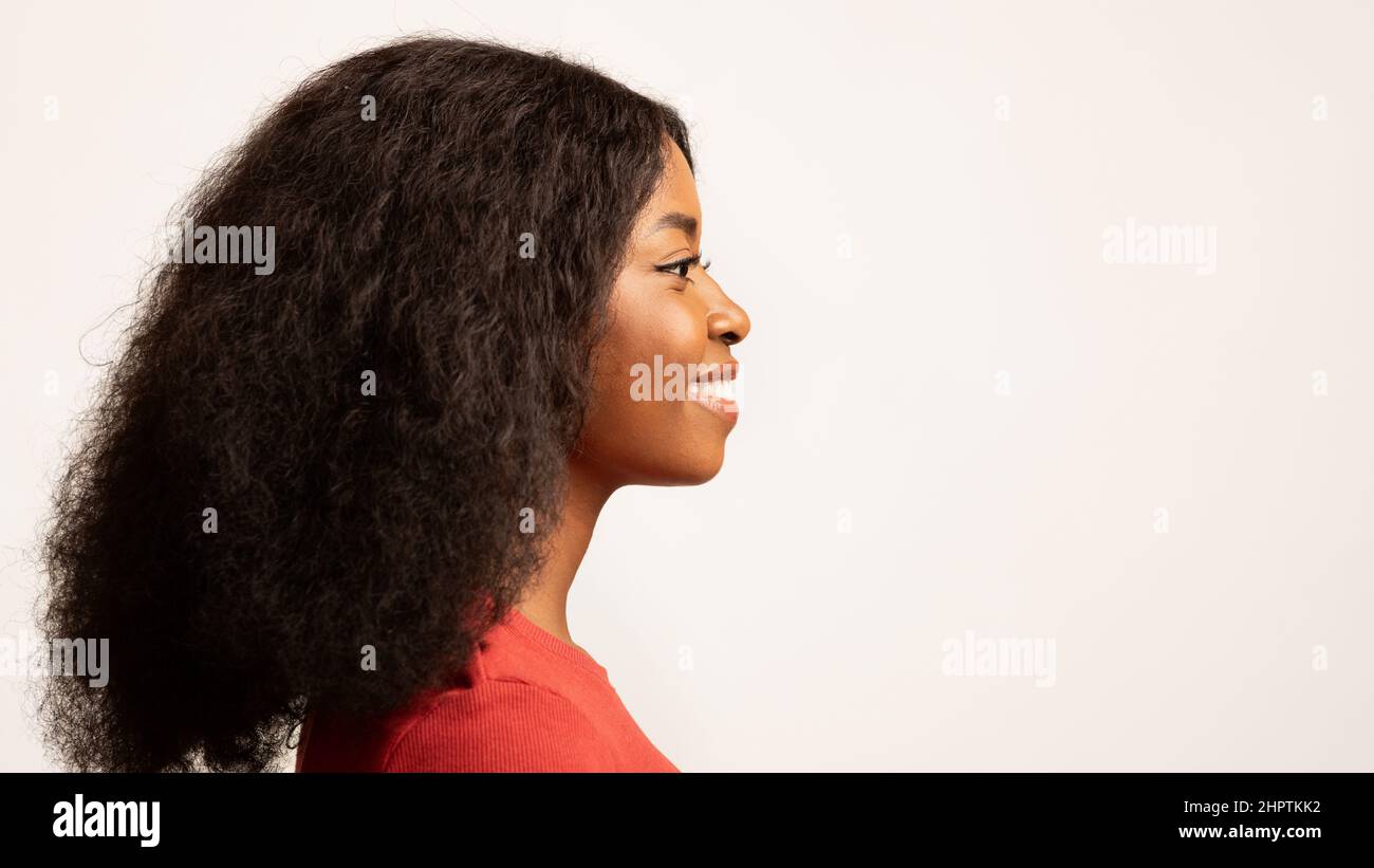 Photo de profil de la femme afro-américaine souriante du millénaire avec les cheveux de Curly Banque D'Images