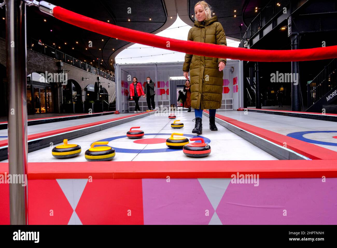 Après le succès de Team GB dans l'épreuve de curling aux Jeux Olympiques d'hiver de 2022, les membres du public essaient une version artificielle du sport sur glace, Londres, Royaume-Uni. Banque D'Images