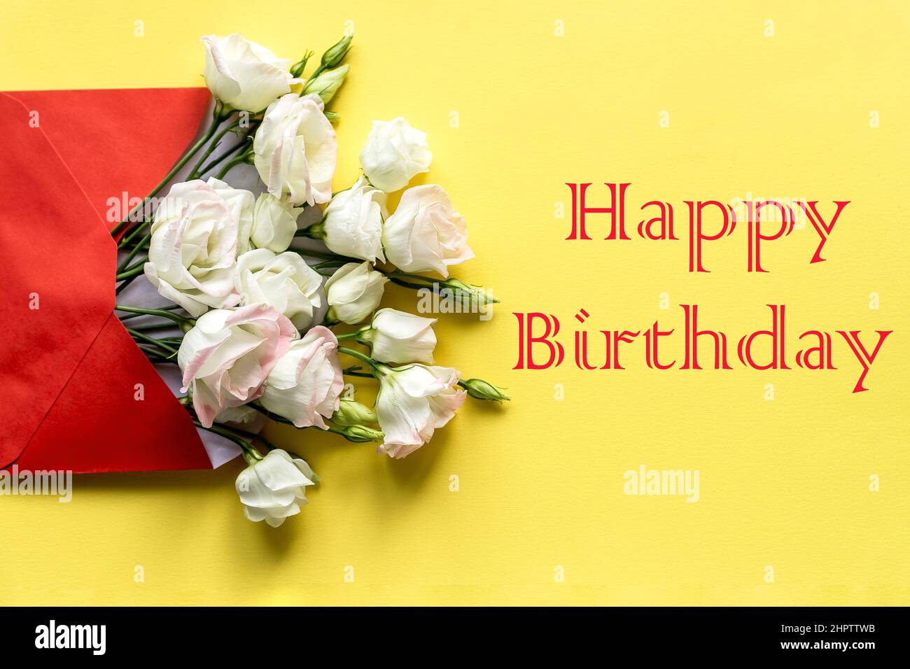 Carte de vœux d'anniversaire élégante. Texte Joyeux anniversaire sur fond jaune.fleurs d'eustoma blanc est dans l'enveloppe. Plat tendance. Banque D'Images