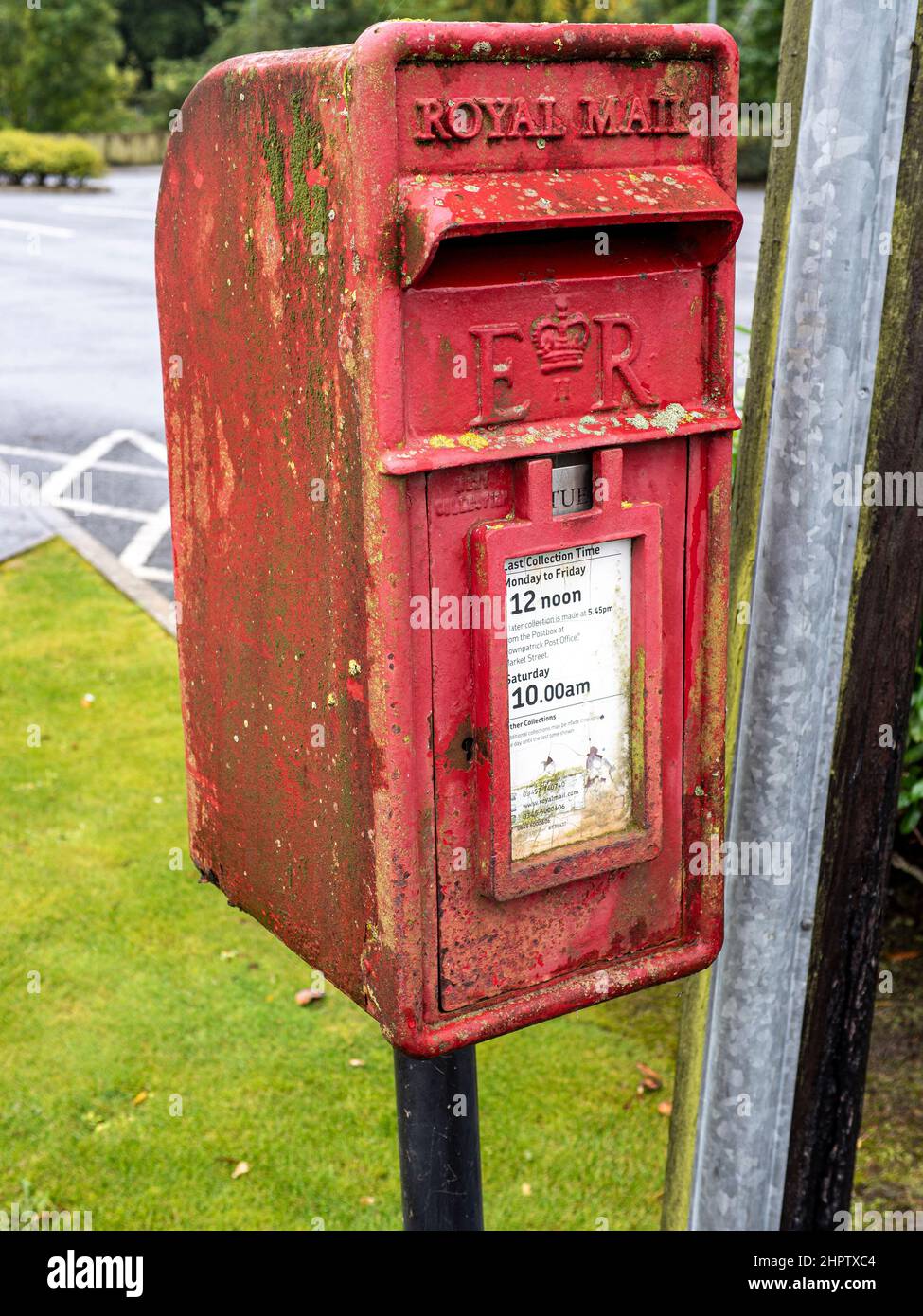 Petite boîte postale royale humide : une petite boîte postale royale en bord de route dans le village de Raffry en Irlande du Nord. Le climat humide a décoré la boîte avec du lichen, de l'algèma et de la rouille. Banque D'Images
