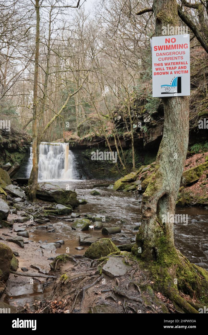 Chute d'eau de Goit stock dans le bois de Goitstock, le long de Harden Beck près de Harden, Bingley, Yorkshire avec un signe d'avertissement de danger de mort Banque D'Images