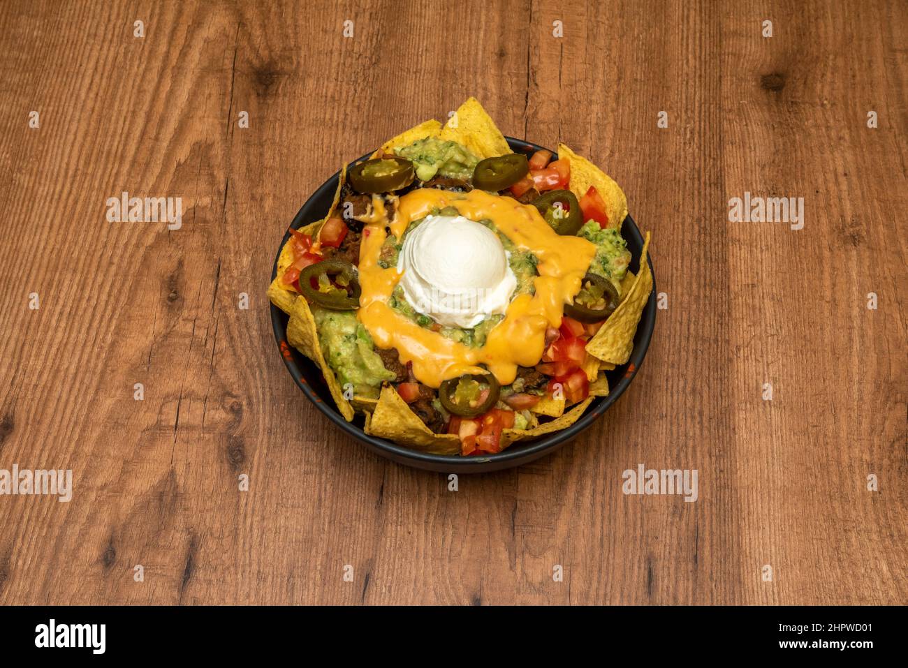 Les nachos au guacamole et au fromage sont un plat facile à préparer, avec lequel vous pouvez offrir à vos invités une option de repas rapide et très savoureux. Banque D'Images