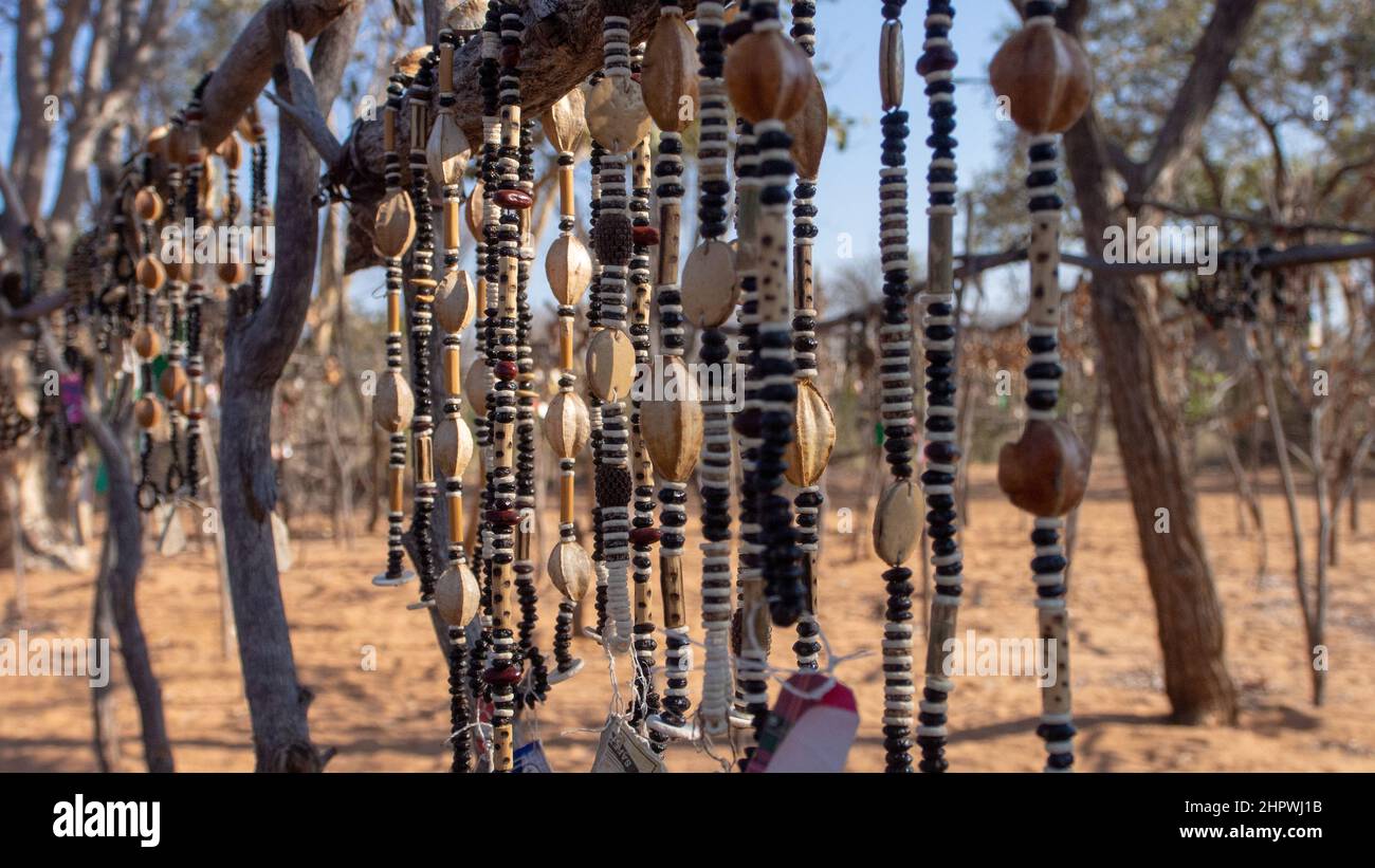 Gros plan de cordes de colliers africains faits de perles et de graines exposées sur un marché extérieur en Namibie. Arrière-plan flou ou flou Banque D'Images