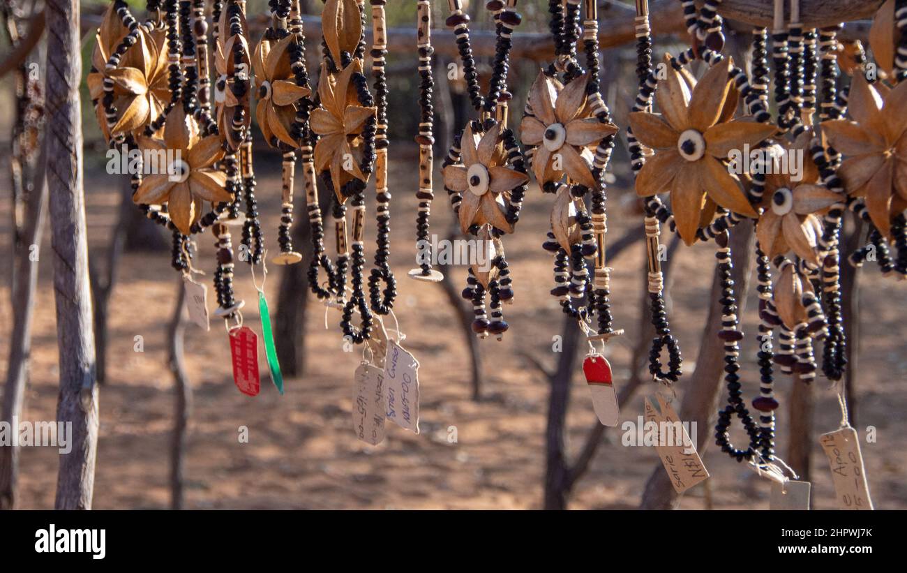 Colliers africains en forme de fleurs faites de graines et de perles exposées sur un marché extérieur en Namibie, Afrique. Arrière-plan flou ou flou Banque D'Images