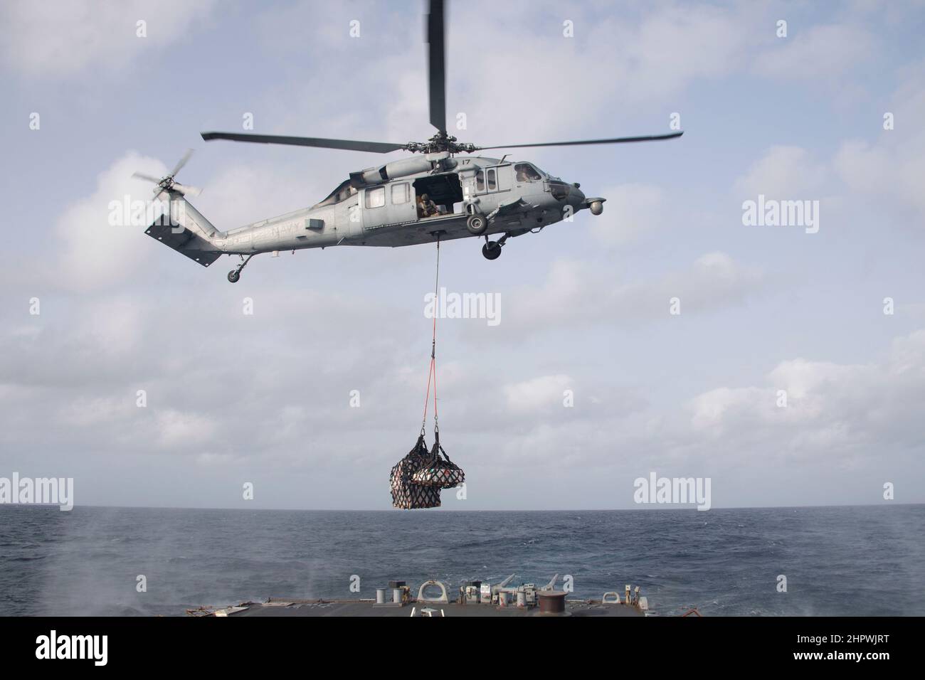 220202-N-QY794-1018 OCÉAN ATLANTIQUE (FÉV 2, 2022) - un hélicoptère MH-60s Sea Hawk, affecté aux "Chevaliers de mer" de l'Escadron de combat de la mer (HSC) 22, abaisse la cargaison jusqu'au pont de vol du destroyer de missiles guidés de la classe Arleigh Burke USS Gonzalez (DDG 66), le 2 février 2022. Gonzalez opère dans l'océan Atlantique à l'appui des opérations navales afin de maintenir la stabilité et la sécurité maritimes afin d'assurer l'accès, de décourager l'agression et de défendre les intérêts américains, alliés et partenaires. (É.-U. Navy photo par Mass communication Specialist 3rd Class Brennen Easter) Banque D'Images