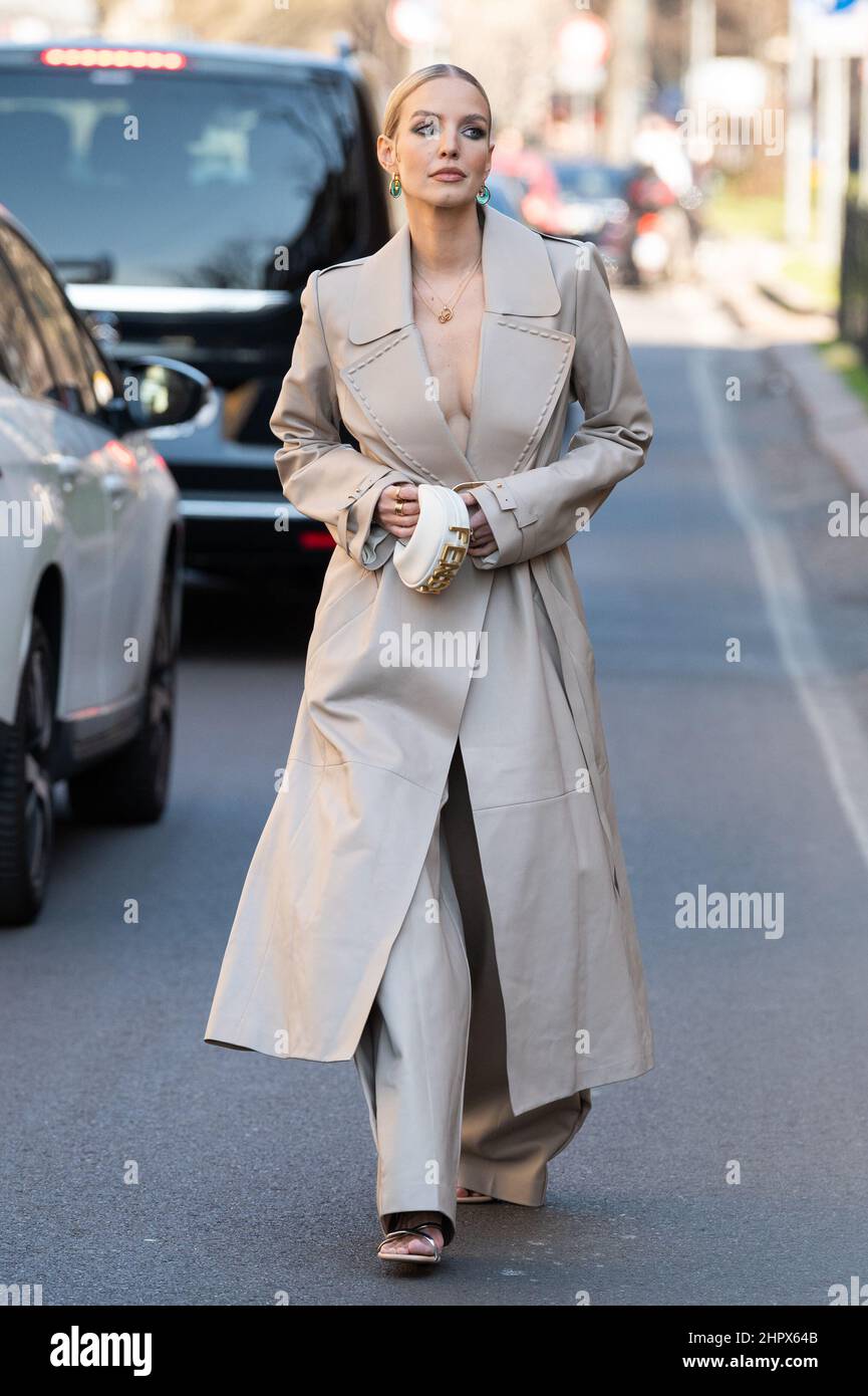Leonie Hanne porte un long manteau en cuir beige mat avec une ceinture de  logo or de Fendi, un sac à main en cuir blanc mat Nano Fendigraphy de  Fendi, MFW 22