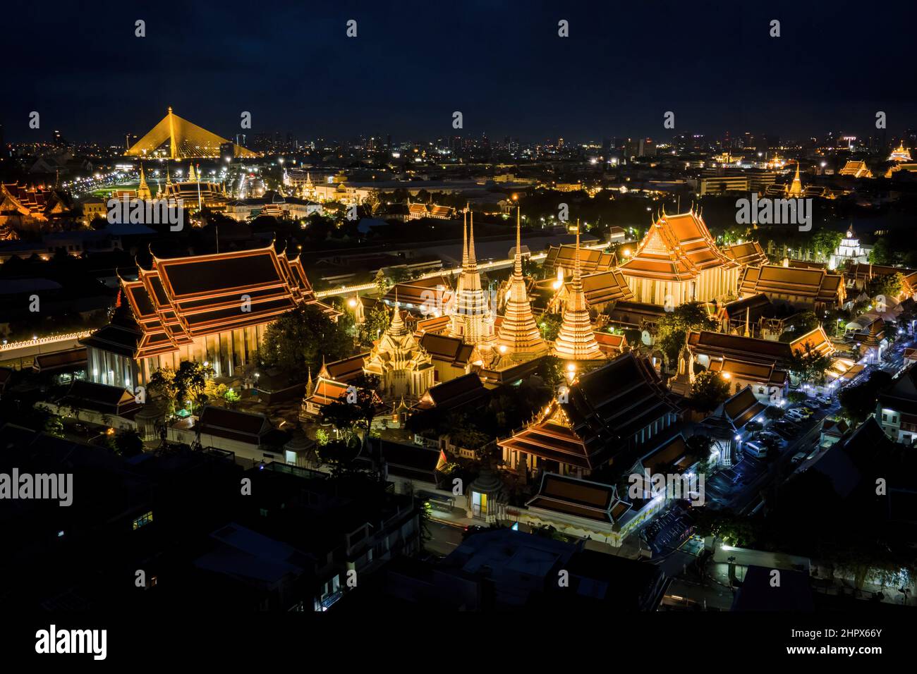 Bangkok, Thaïlande. 25th juillet 2021. (NOTE DE LA RÉDACTION : image prise avec un drone)vue aérienne du Grand Palais de Bangkok. Deux des plus célèbres sites du patrimoine culturel et attractions touristiques de Thaïlande, Wat Arun (Temple de l'Aube) et le Grand Palais, sont illuminés la nuit le long de la rivière Chao Praya à Bangkok. Le Gouvernement thaïlandais a récemment annoncé un renforcement des conditions d'entrée pour les touristes internationaux en Thaïlande dans le contexte d'une poussée de la variante Omicron de la COVID-19 dans tout le pays, avec des cas de plus de 20 000 infections signalées par jour. Crédit : SOPA Images Limited/Alamy Live News Banque D'Images