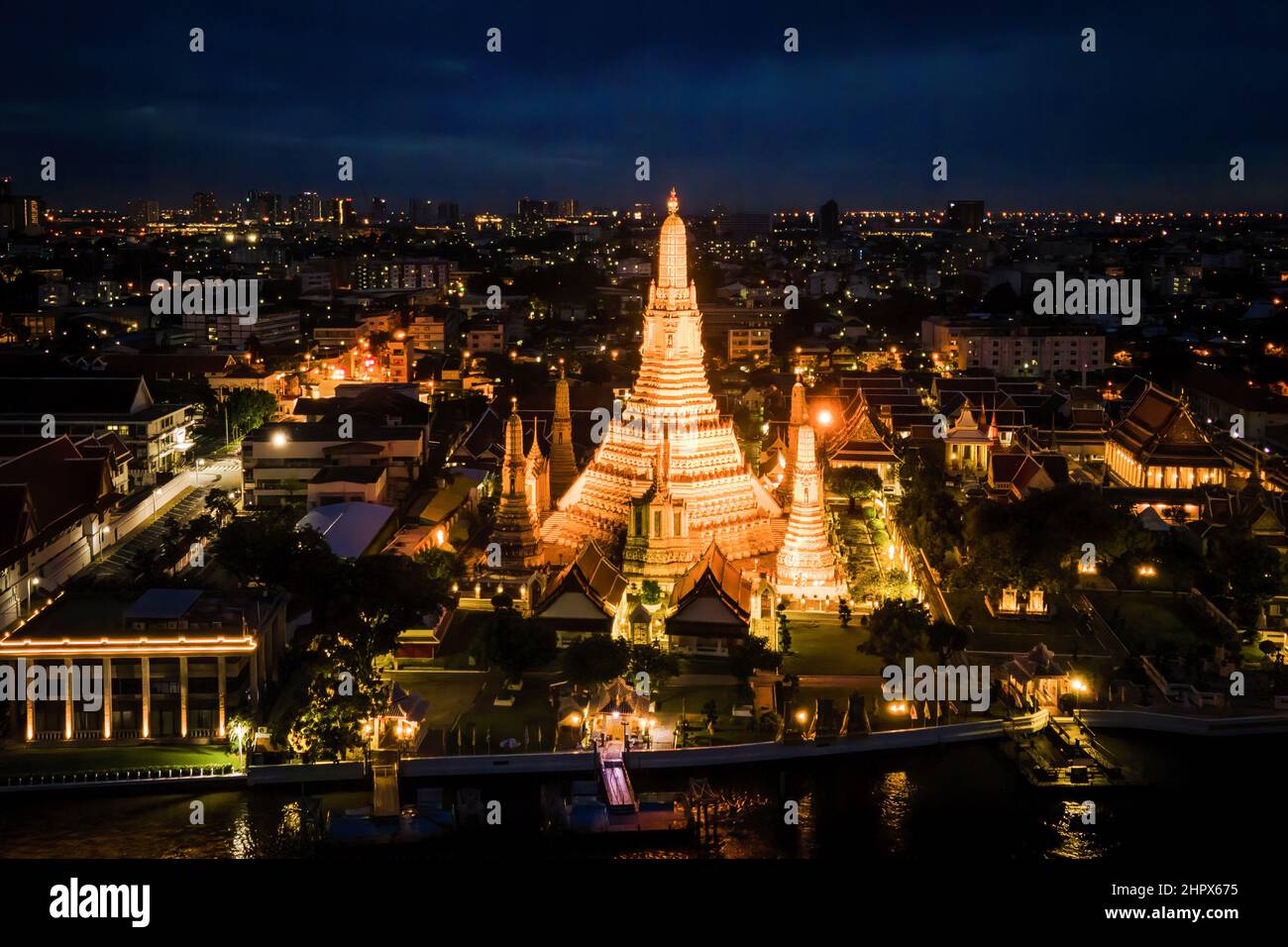 (NOTE DE LA RÉDACTION: Image prise avec drone)vue aérienne de Wat Arun, le Temple de l'Aube, à Bangkok. Deux des plus célèbres sites du patrimoine culturel et attractions touristiques de Thaïlande, Wat Arun (Temple de l'Aube) et le Grand Palais, sont illuminés la nuit le long de la rivière Chao Praya à Bangkok. Le Gouvernement thaïlandais a récemment annoncé un renforcement des conditions d'entrée pour les touristes internationaux en Thaïlande dans le contexte d'une poussée de la variante Omicron de la COVID-19 dans tout le pays, avec des cas de plus de 20 000 infections signalées par jour. Banque D'Images