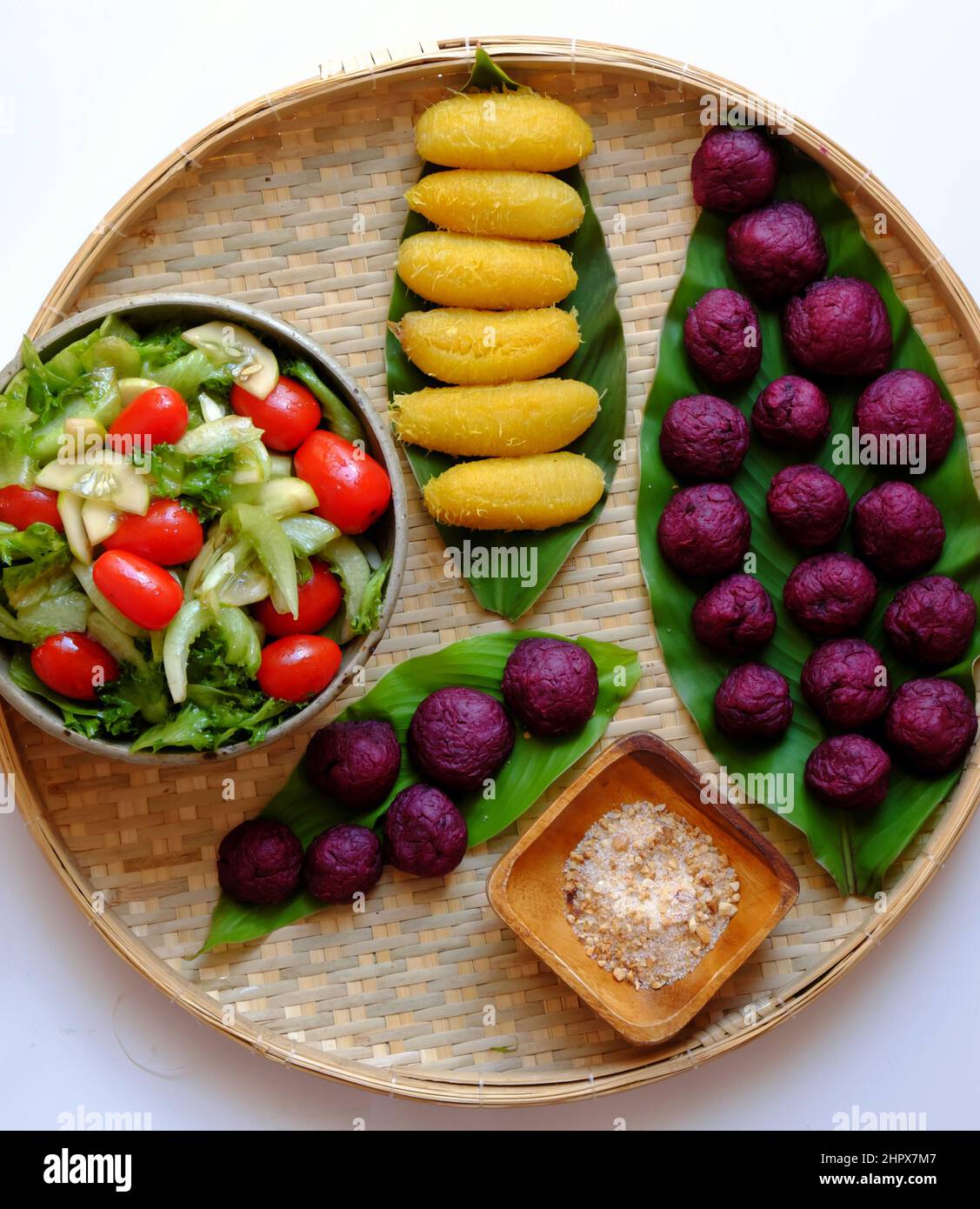 Plateau avec vue sur le dessus de la nourriture végétalienne de la patate douce violette, de la banane bouillie et de la salade avec de la tomate pour un dîner simple, un menu sans viande sera bon pour la santé Banque D'Images