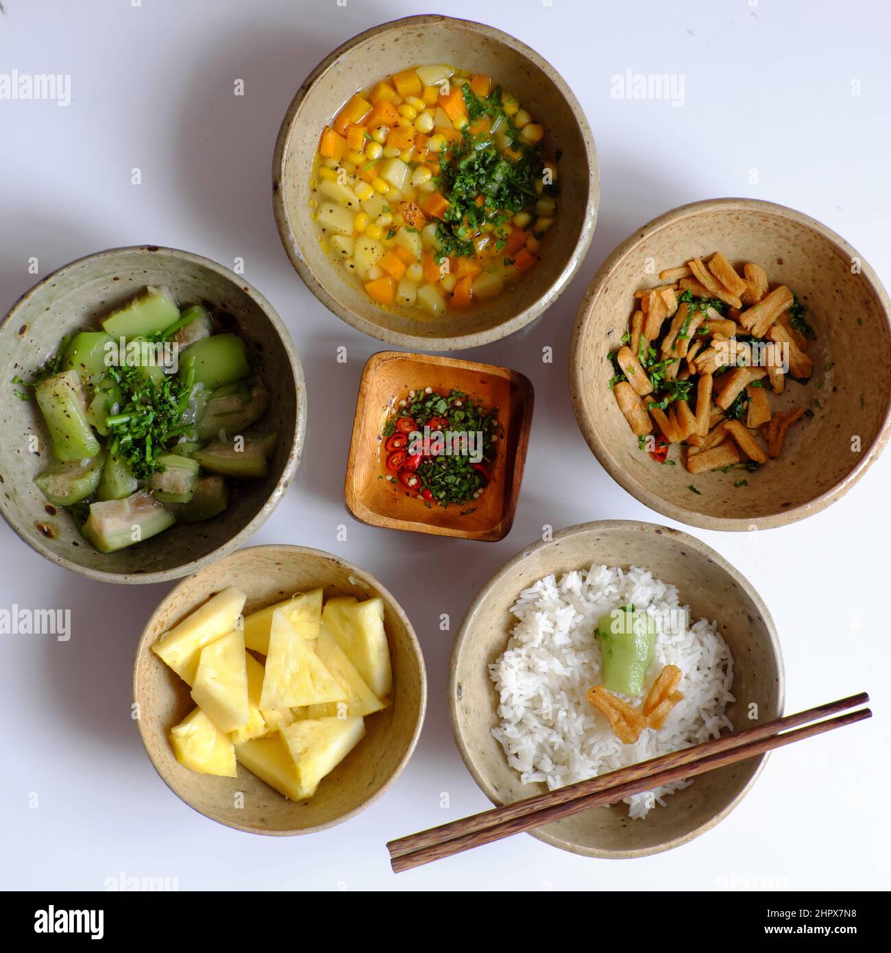 Vue de dessus repas du jour vietnamien pour le déjeuner, plateau de riz avec melon, bol à soupe de carottes, maïs, pomme de terre, tofu frits, ananas, sauce, v Banque D'Images