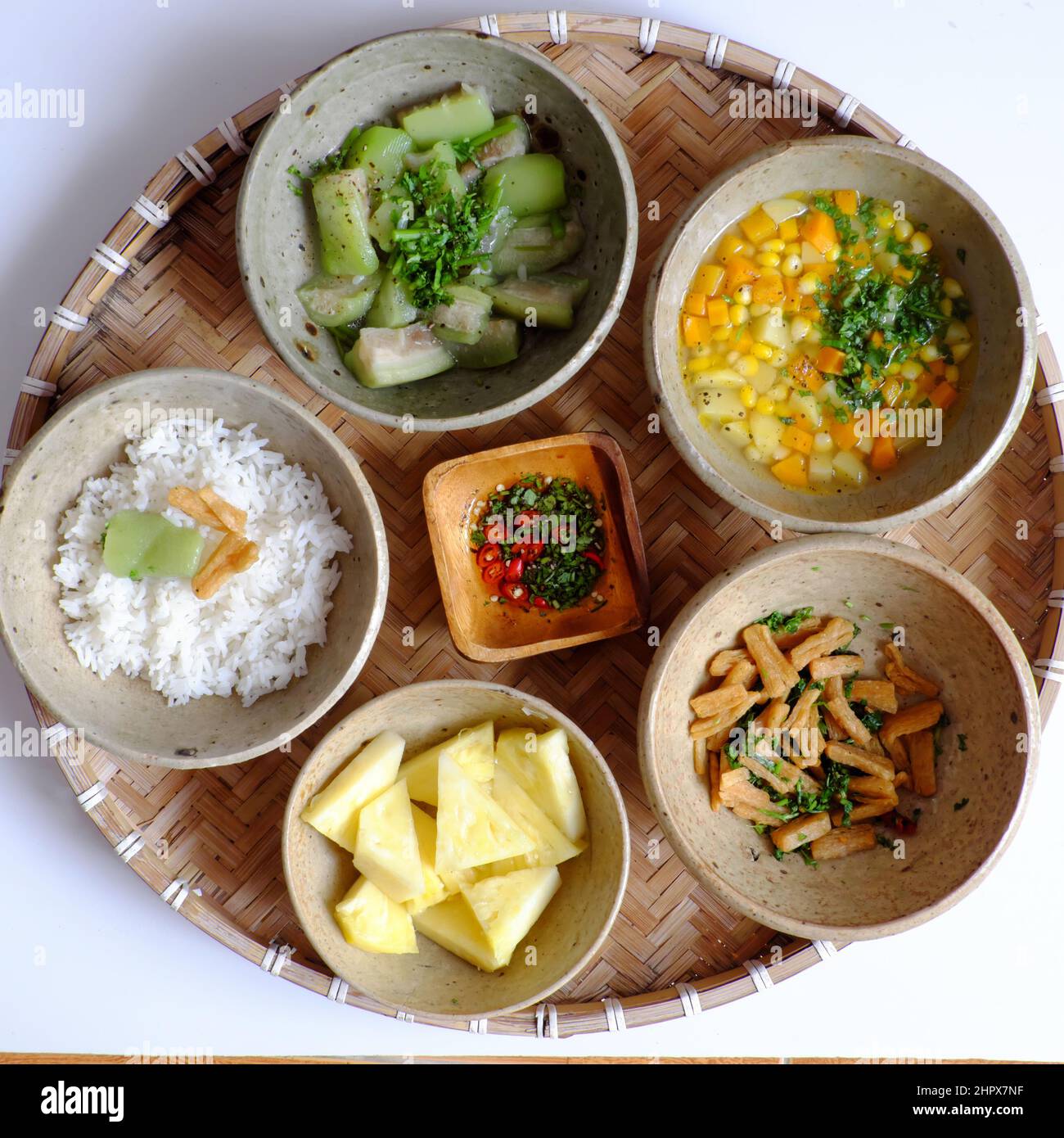 Vue de dessus repas du jour vietnamien pour le déjeuner, plateau de riz avec melon, bol à soupe de carottes, maïs, pomme de terre, tofu frits, ananas, sauce, v Banque D'Images