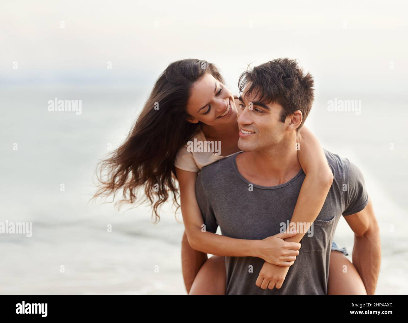 J'ai toujours eu votre dos, babe. Photo courte d'un jeune couple affectueux à la plage. Banque D'Images