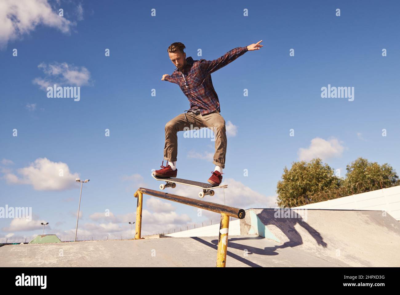 Comme le vol. Photo d'un skateboarder effectuant un tour sur un rail. Banque D'Images