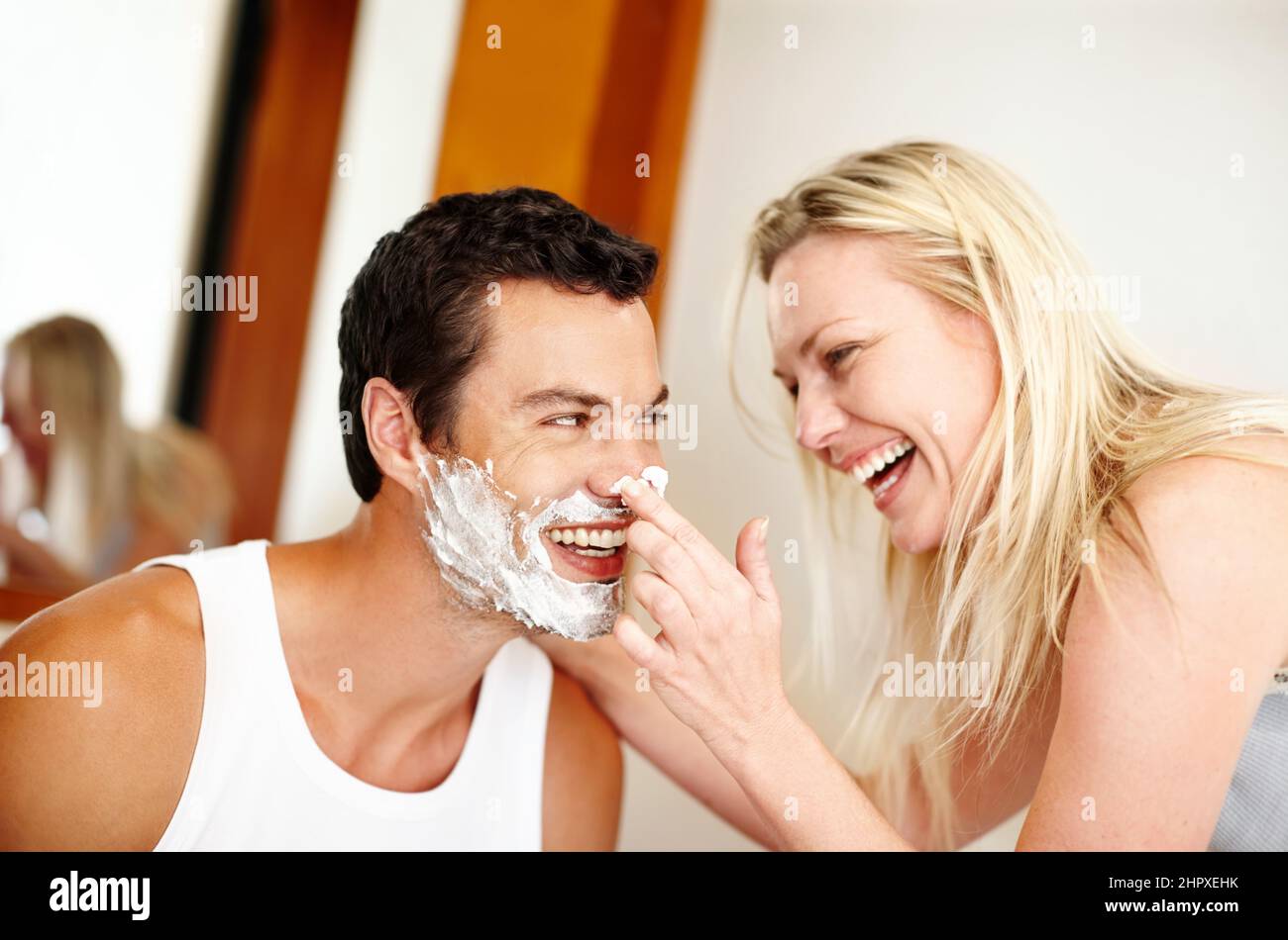 Les meilleurs amis font les meilleures relations. Photo d'une jeune femme qui met de la crème à raser sur son mari et qui rit. Banque D'Images