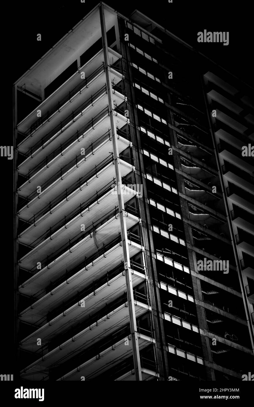 Image en noir et blanc d'un bâtiment inachevé à plusieurs étages dans une clé basse. Vue sur le bâtiment non fini la nuit. Banque D'Images