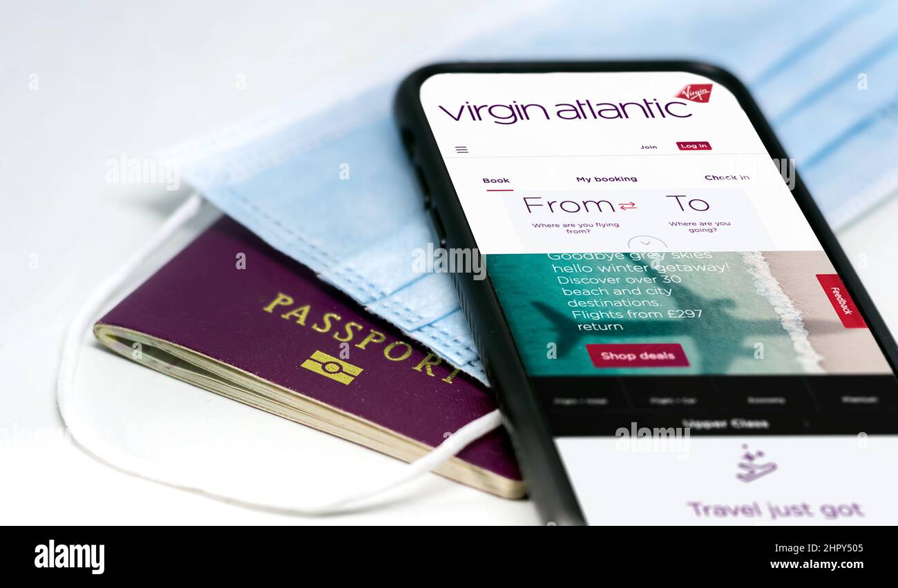 Londres, Royaume-Uni, juillet 2021 : téléphone avec l'application Virgin Atlantic Airlines à l'écran, au-dessus d'un masque de protection et d'un passeport. Sécurité et sécurité des déplacements Banque D'Images
