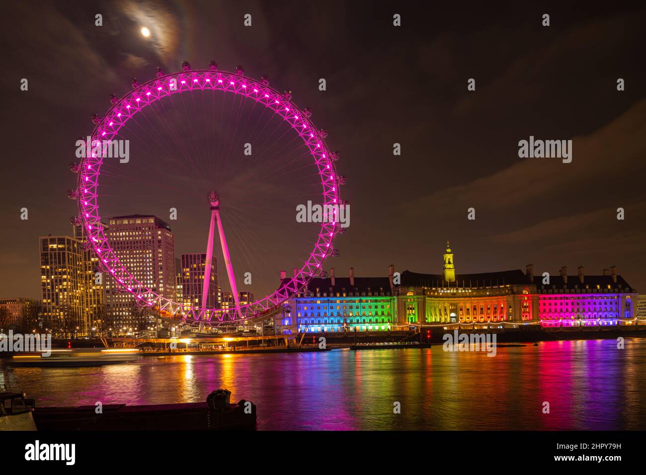 Le London Eye et le Old County Hall illuminés la nuit avec une pleine lune derrière Banque D'Images