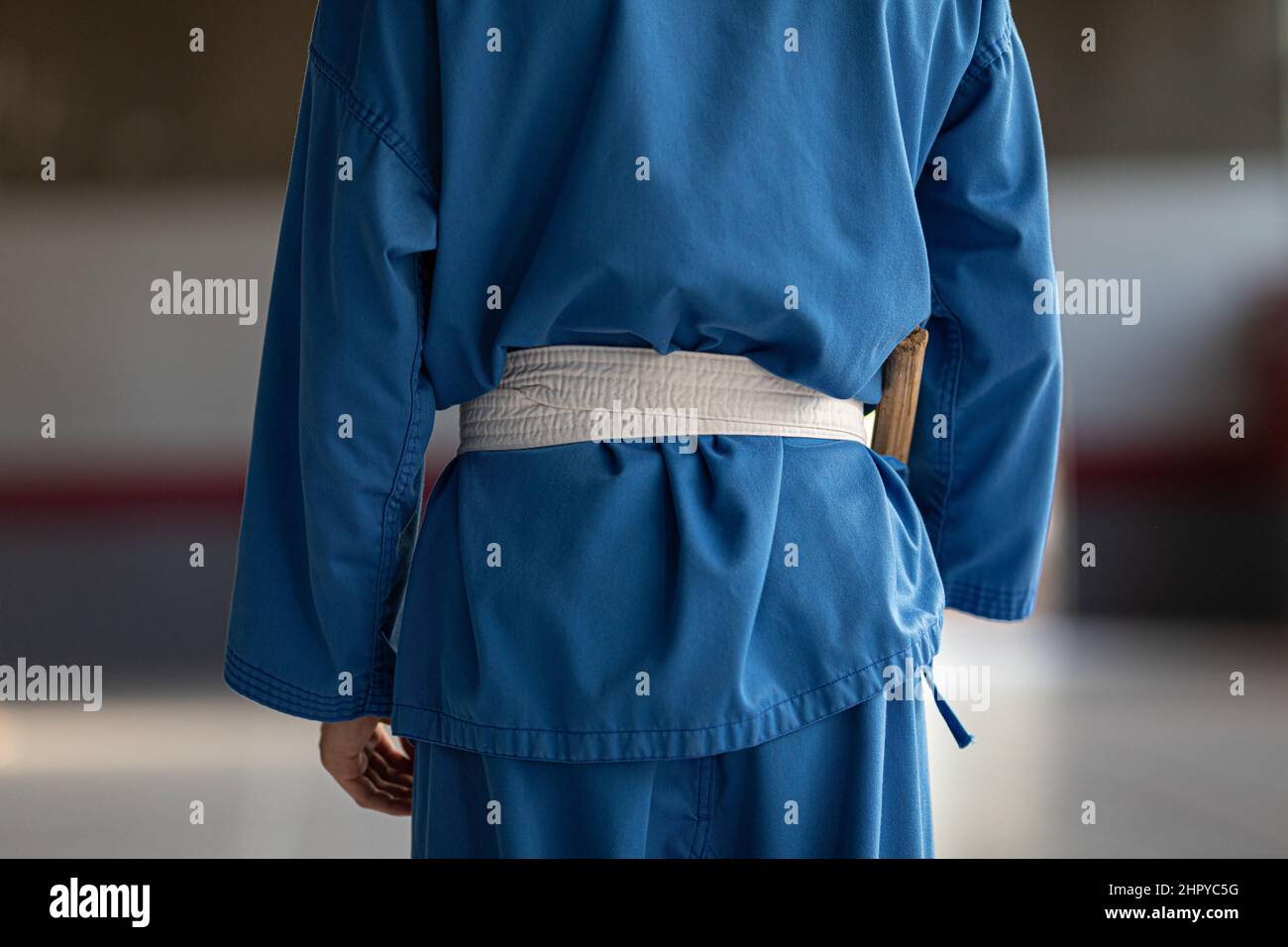 Personne en uniforme de judo bleu avec une ceinture d'art martial blanche  Photo Stock - Alamy