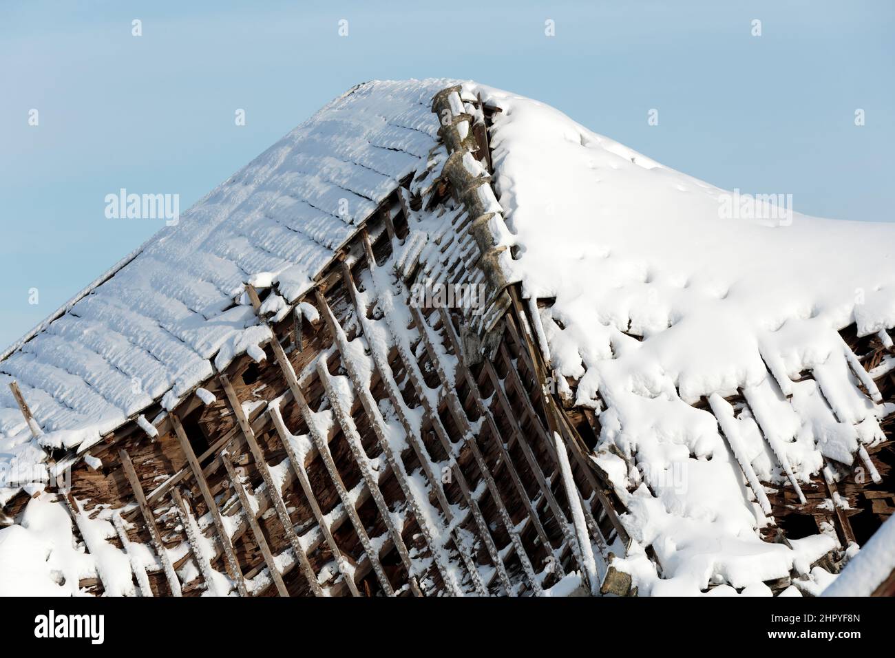 Une ancienne grange avec un toit écroulé le jour d'hiver ensoleillé Banque D'Images