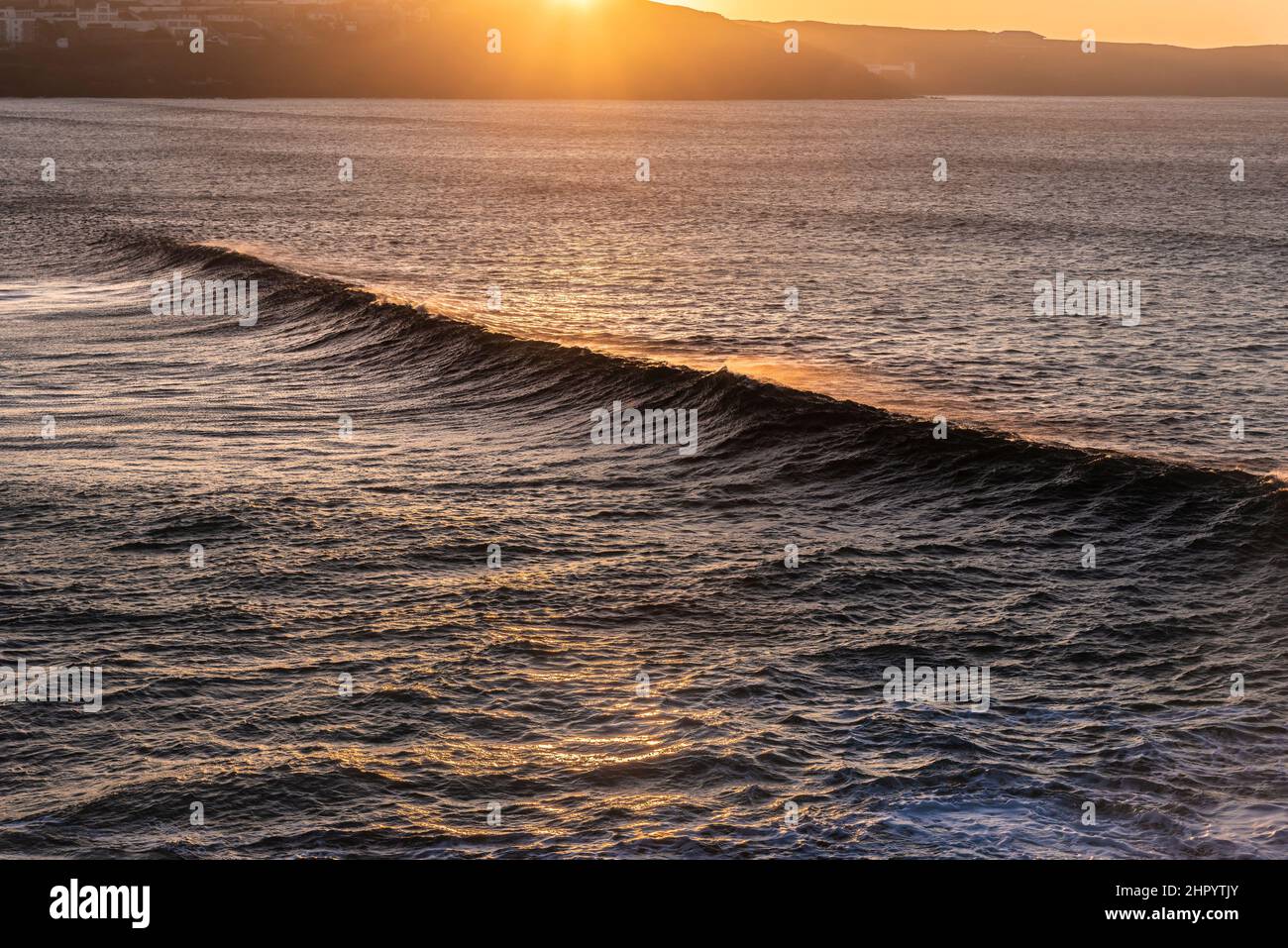 Lumière dorée intense d'un spectaculaire coucher de soleil sur la baie de Fistral à Newquay, en Cornouailles. Banque D'Images