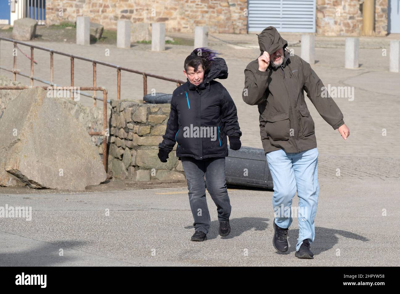 Les gens qui luttent pour marcher dans le vent de force de tempête apporté par Storm Eunice lorsqu'il arrive à Newquay, en Cornwall. Banque D'Images