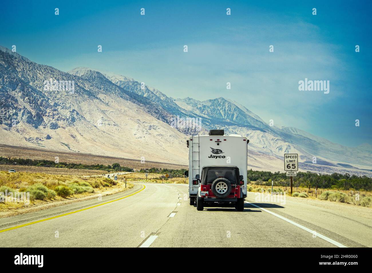 2021 05 25 Eastern California USA - camping-car remorquant des Jeep sur une route en courbe avec les montagnes de la Sierra Nevada en arrière-plan dans un environnement aride de de l'EAS Banque D'Images