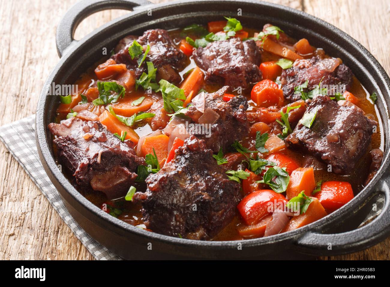 Estofado de Rabo de Toro Spanish Oxtail assemblage sur une casserole sur la table en bois. Horizontale Banque D'Images