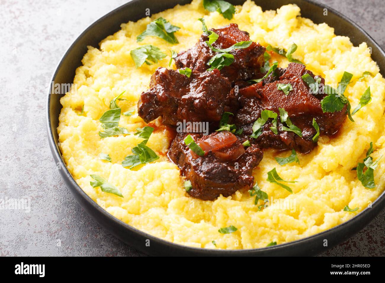 Rabada Oxtail Stew in Red Wine closeup sur la plaque sur la table en béton. Horizontale Banque D'Images