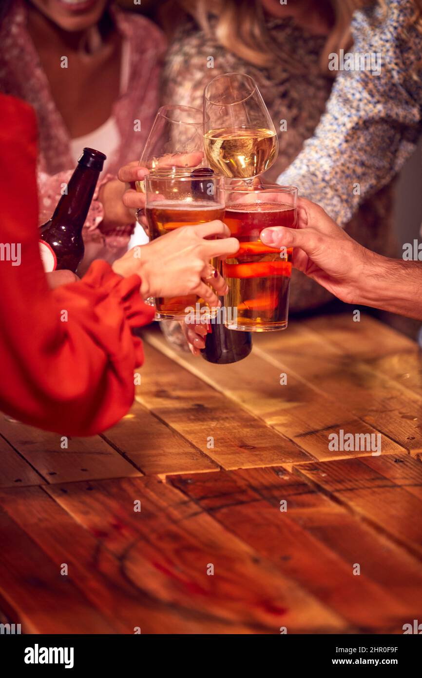 Gros plan sur des amis qui s'amusent la nuit à boire au bar pour faire un toast Banque D'Images