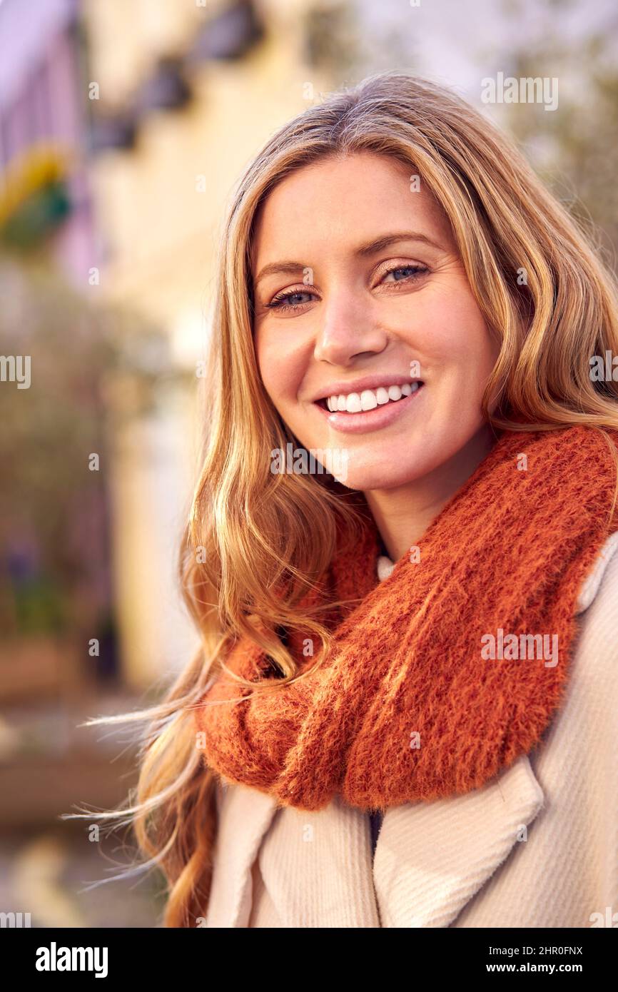 Extérieur tête et épaules Portrait d'une femme souriante portant un manteau et une écharpe en automne ou en automne Banque D'Images