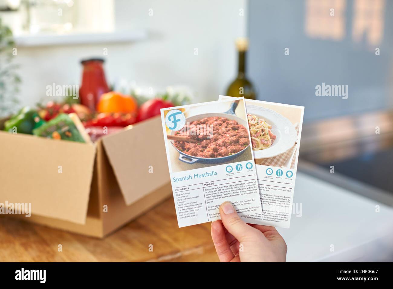 Gros plan dans la cuisine contenant des fiches de recettes pour le kit de recettes de repas en ligne livré à la maison Banque D'Images