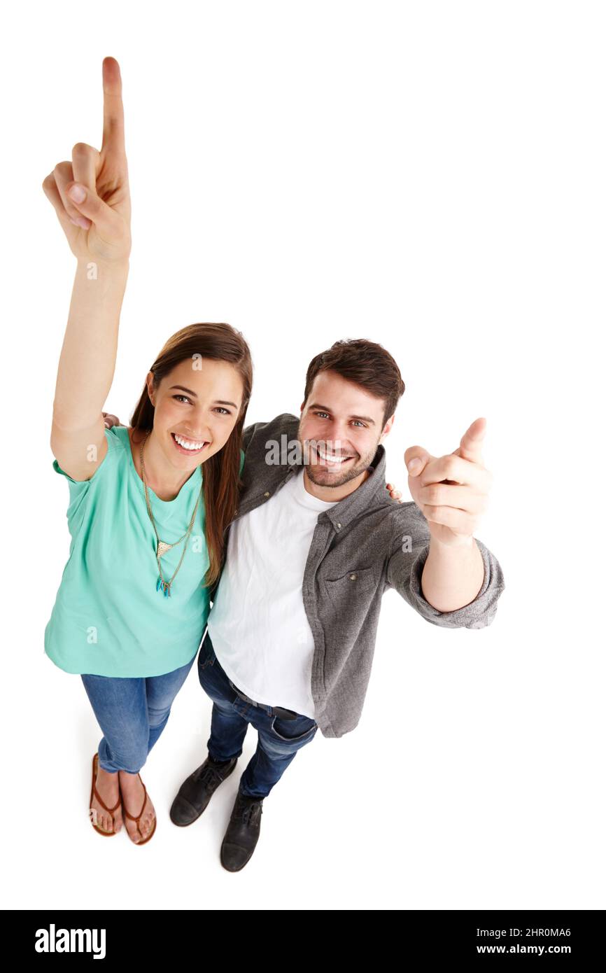 Visez le succès. Photo en grand angle d'un jeune couple heureux en studio, en levant les bras et en pointant vers le haut. Banque D'Images