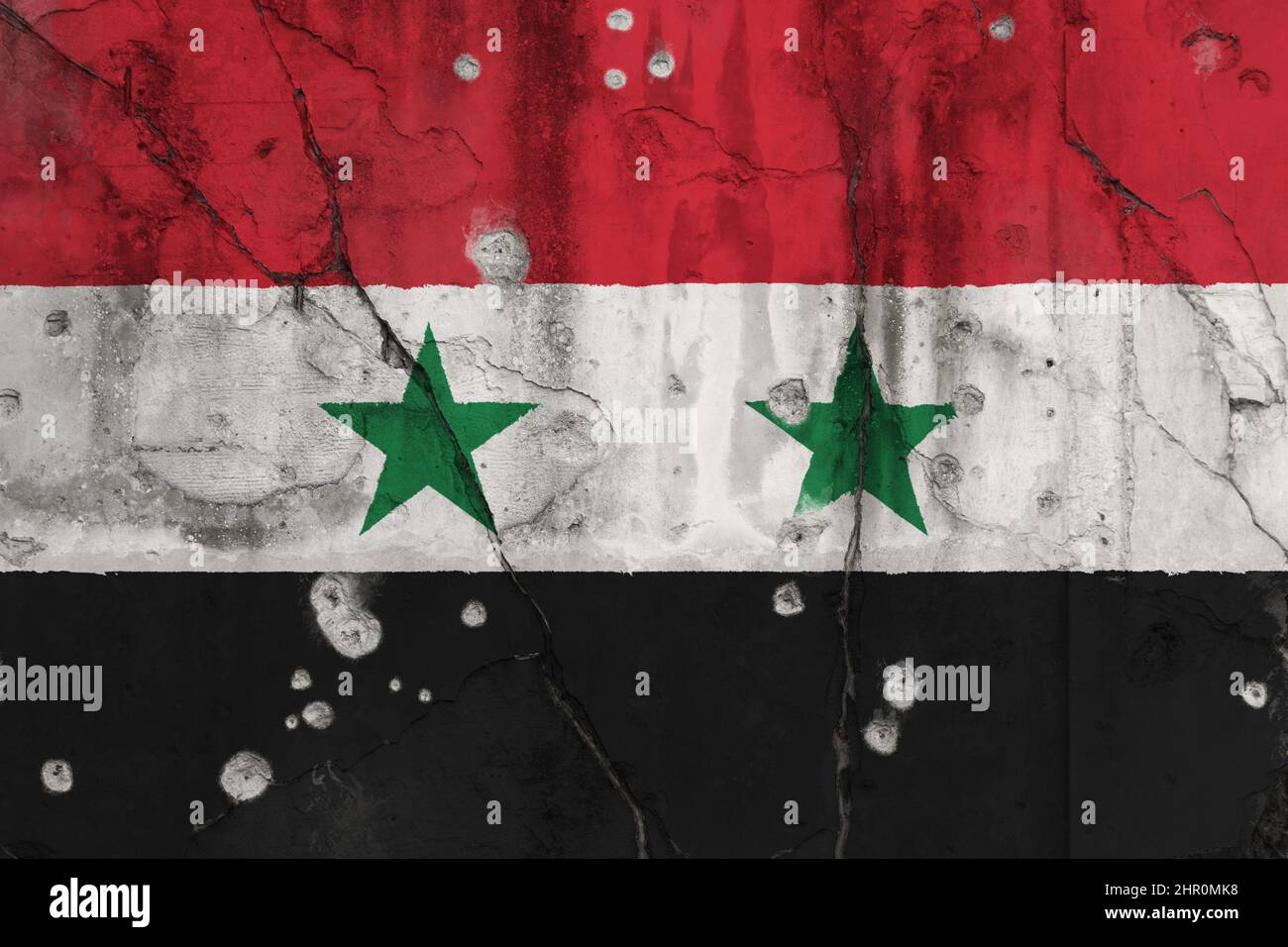 Photo plein cadre d'un drapeau de Syrie abîmé peint sur un mur fissuré avec des trous de balle. Guerre civile syrienne et concept de violence. Banque D'Images