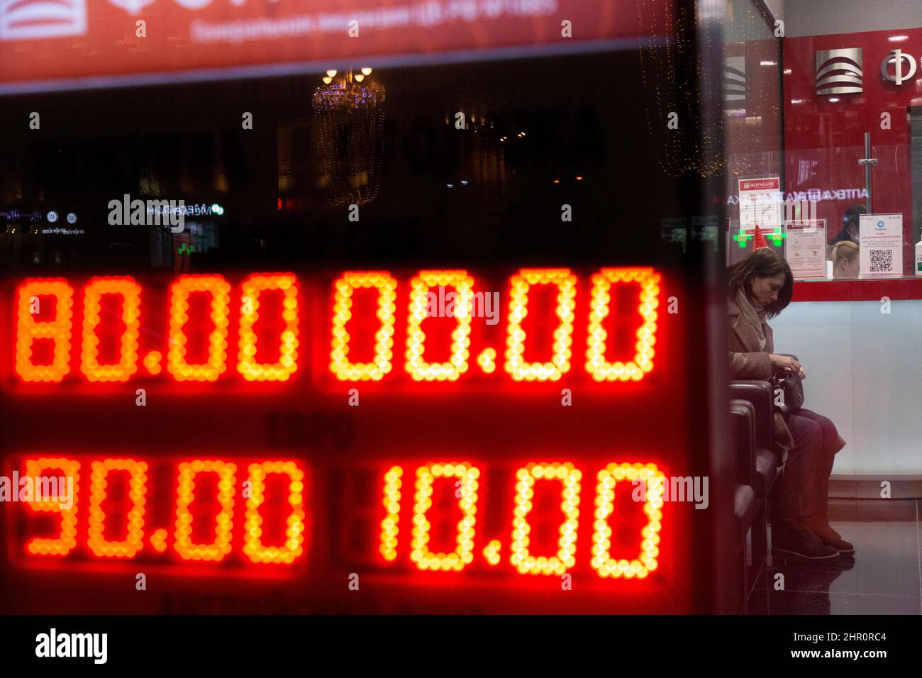 Moscou, Russie. 24th de février 2022 client de la Fora Bank passé un  tableau numérique affichant les taux actuels à l'extérieur d'un bureau de  change. En 10am, la Bourse de Moscou a